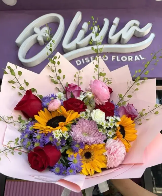 Enchanted Love – Ramo talla L con girasoles, rosas rojas, ranúnculos y flores de complemento.