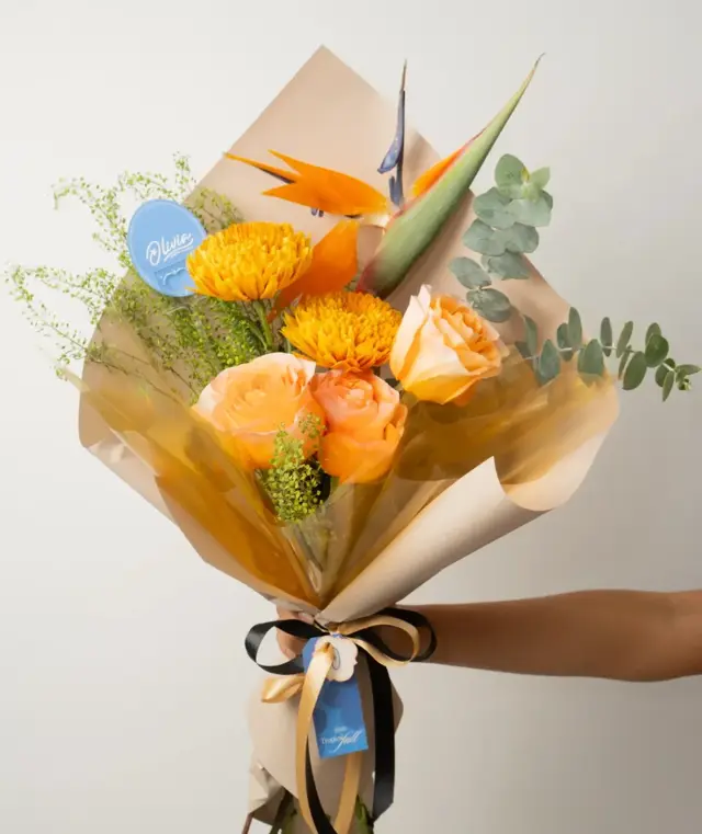 Sienna Bouquet – Ramo de ave del paraíso, rosas durazno y crisantemos amarillos con eucalipto.